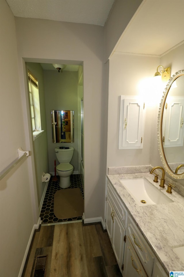 full bath with vanity, baseboards, toilet, and wood finished floors
