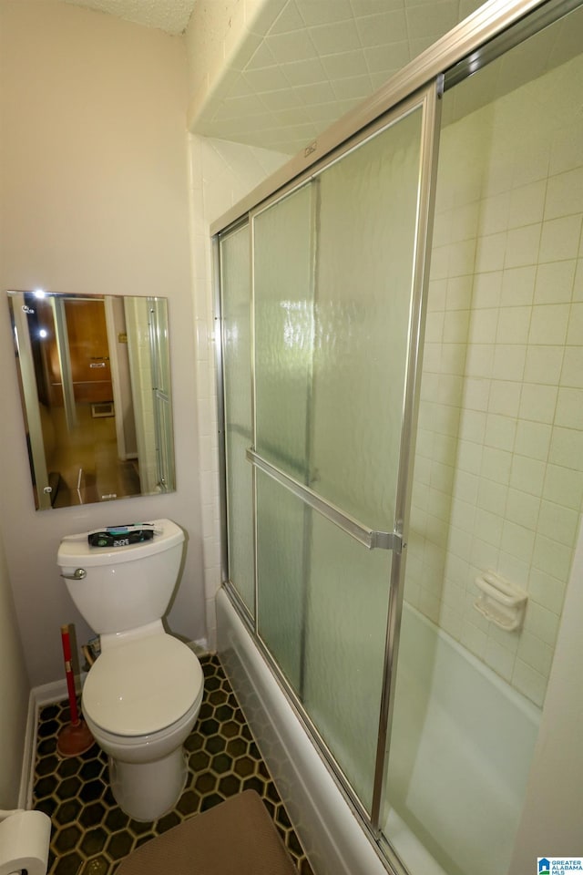bathroom with tile patterned floors, enclosed tub / shower combo, baseboards, and toilet