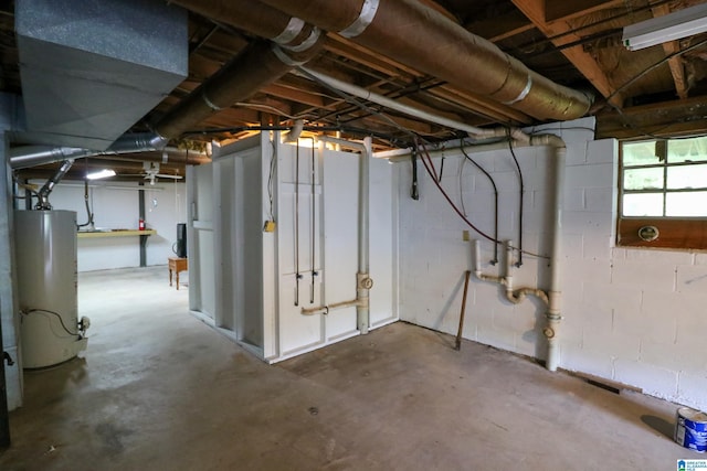 below grade area featuring concrete block wall and gas water heater