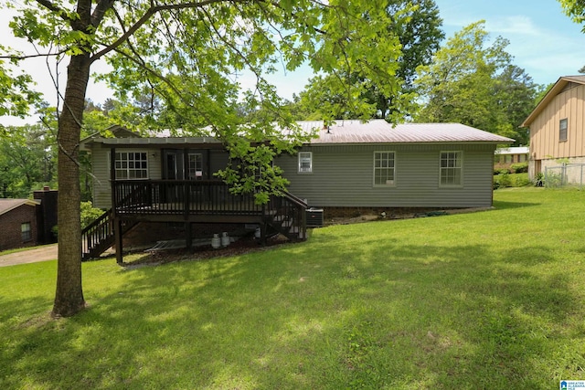 back of house with a lawn, a wooden deck, metal roof, and stairway