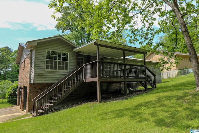 rear view of house with a lawn, fence, a wooden deck, and stairs