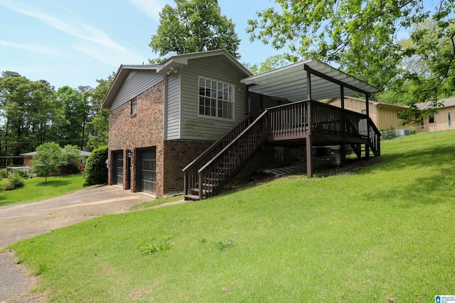 rear view of property featuring driveway, stairway, brick siding, a yard, and an attached garage