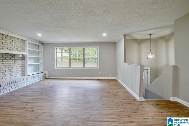 unfurnished living room featuring recessed lighting, a textured ceiling, baseboards, built in shelves, and wood finished floors