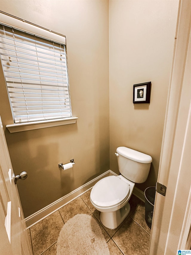 bathroom featuring toilet, baseboards, and tile patterned floors