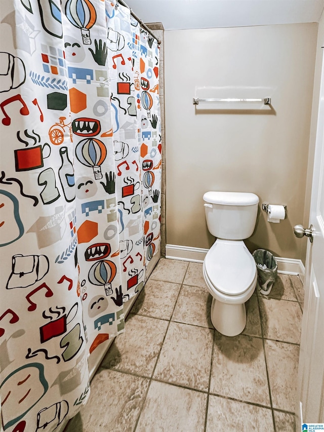 bathroom featuring baseboards, toilet, tile patterned flooring, and curtained shower