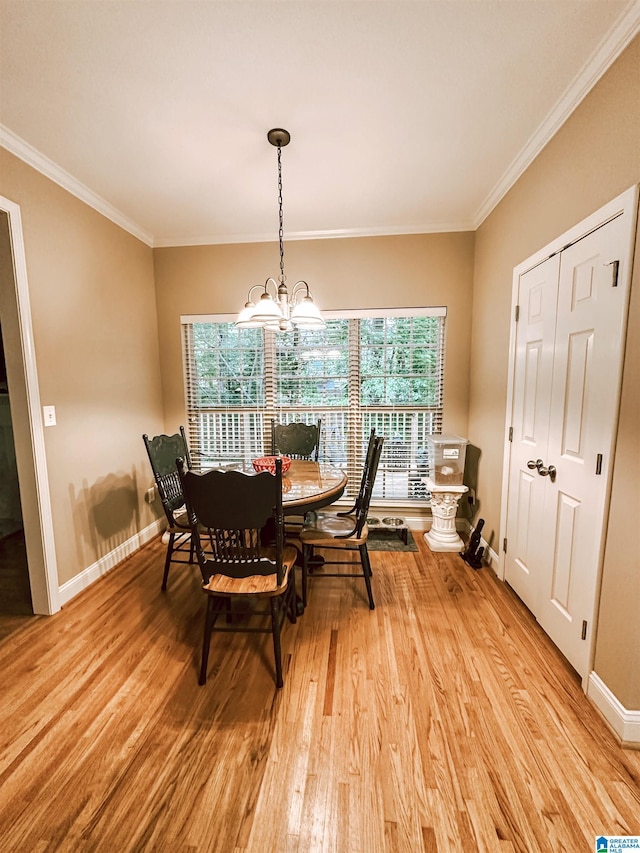 dining room featuring light wood-style flooring, a chandelier, ornamental molding, and baseboards