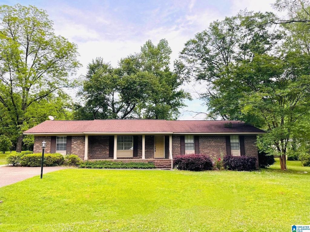 ranch-style home featuring a porch, a front lawn, and brick siding