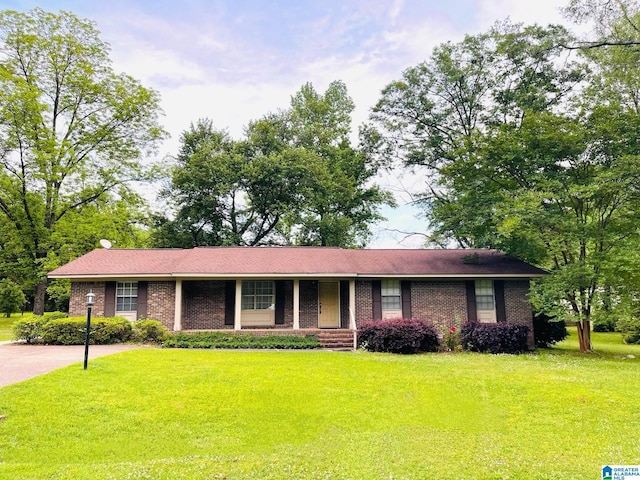 ranch-style home featuring a porch, a front lawn, and brick siding