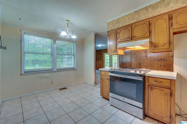 105 Campbell Rd, Clanton, AL 35045 - kitchen featuring under cabinet range hood, an inviting chandelier, wooden walls, light countertops, and stainless steel range with electric cooktop