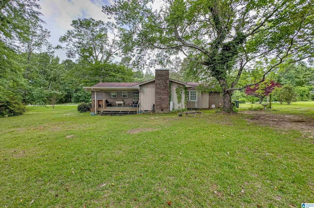 105 Campbell Rd, Clanton, AL 35045 - rear view of house featuring brick siding, a yard, a chimney, and a wooden deck