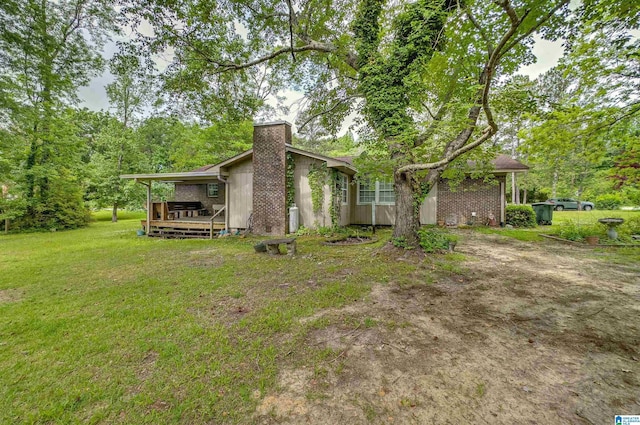 105 Campbell Rd, Clanton, AL 35045 - back of house featuring a yard, a wooden deck, and a chimney