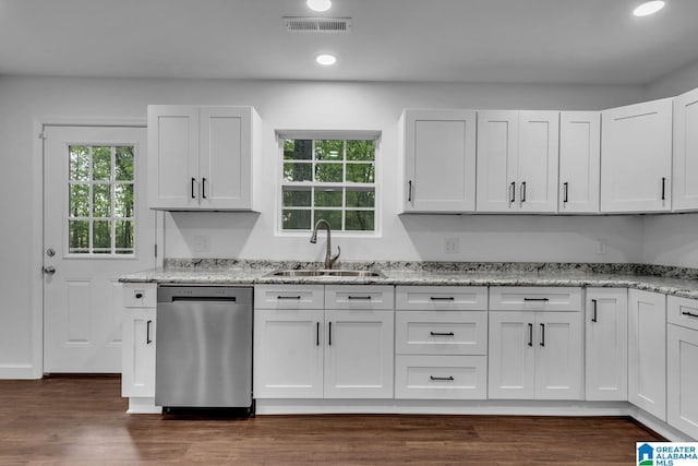 kitchen with light stone counters, a sink, dark wood-type flooring, stainless steel dishwasher, and visible vents