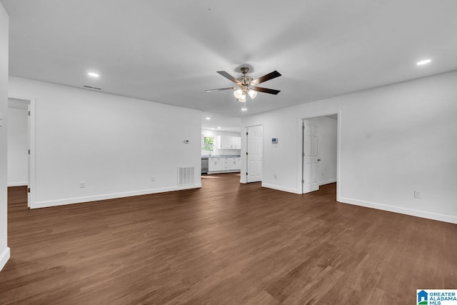 unfurnished living room featuring visible vents, baseboards, ceiling fan, and dark wood-style flooring