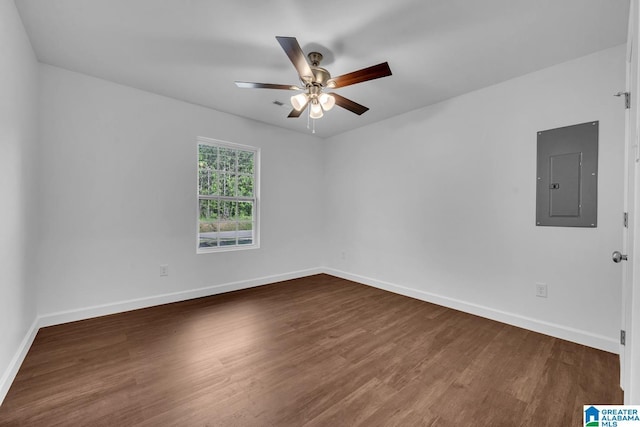 unfurnished room with baseboards, ceiling fan, wood finished floors, and electric panel