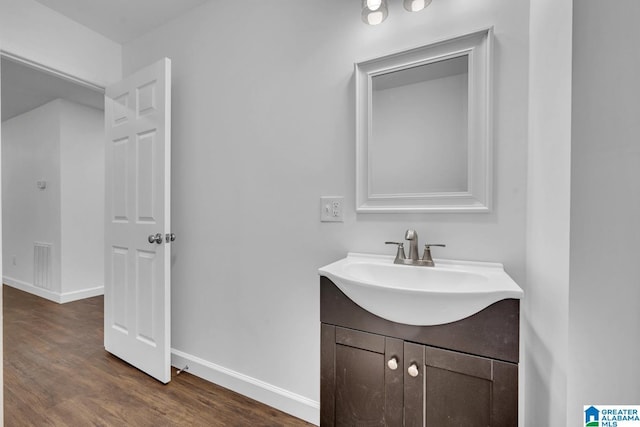 bathroom with baseboards, visible vents, wood finished floors, and vanity