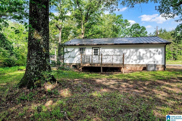 rear view of house with central AC, metal roof, crawl space, and a deck