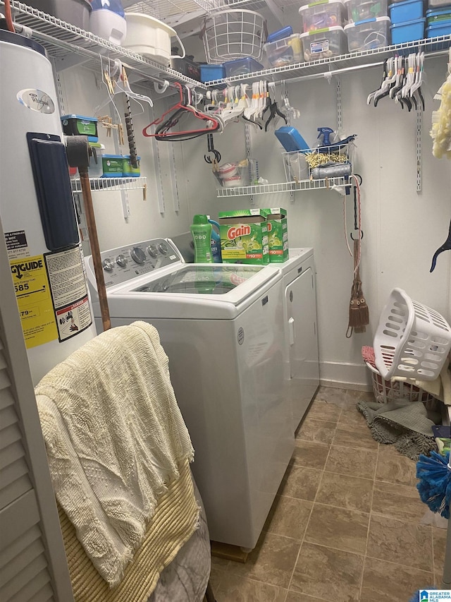 laundry room with water heater, baseboards, laundry area, and washing machine and clothes dryer