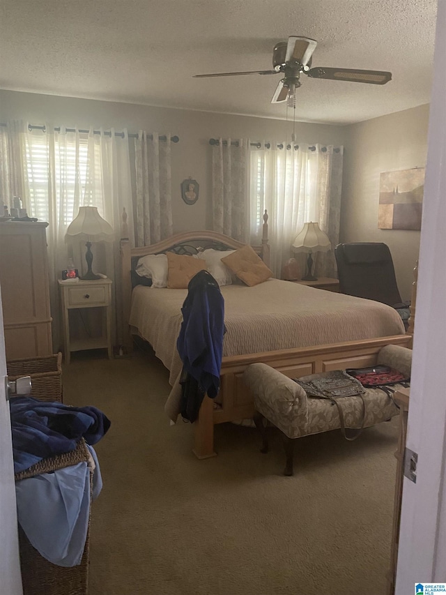carpeted bedroom featuring a textured ceiling and ceiling fan