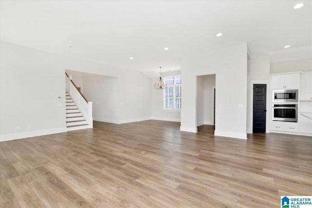 4546 Brexton St, Trussville, AL 35173 - unfurnished living room with stairway, baseboards, light wood finished floors, and a chandelier