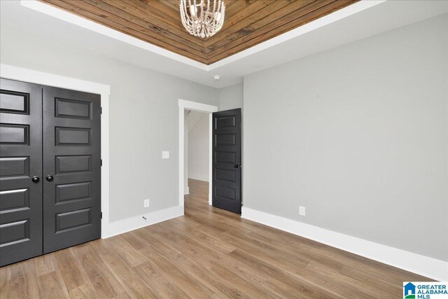 4546 Brexton St, Trussville, AL 35173 - unfurnished bedroom with baseboards, a raised ceiling, light wood-style flooring, and a chandelier