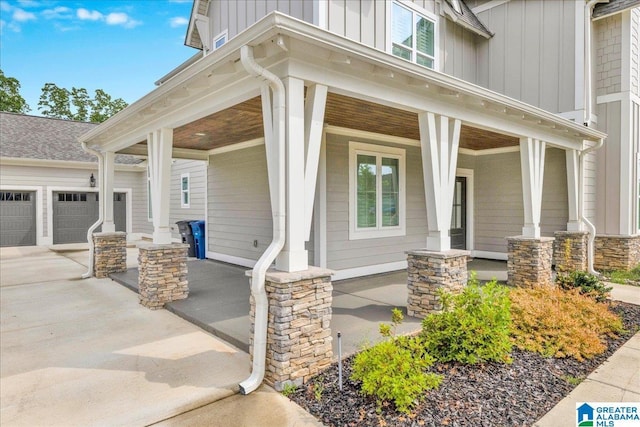 4546 Brexton St, Trussville, AL 35173 - entrance to property featuring a porch, board and batten siding, a garage, concrete driveway, and stone siding