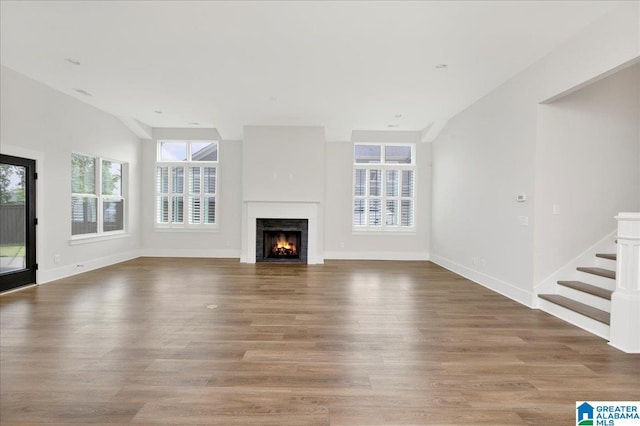 4546 Brexton St, Trussville, AL 35173 - unfurnished living room featuring baseboards, wood finished floors, a lit fireplace, and stairway