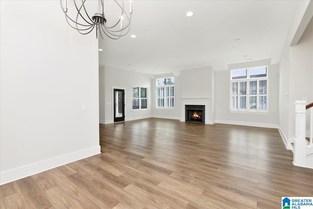 4546 Brexton St, Trussville, AL 35173 - unfurnished living room with recessed lighting, baseboards, light wood finished floors, and a warm lit fireplace