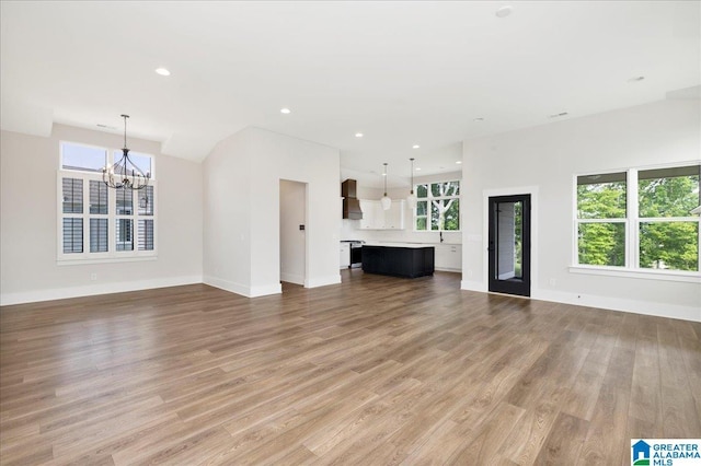 4546 Brexton St, Trussville, AL 35173 - unfurnished living room with baseboards, a chandelier, a wealth of natural light, and light wood finished floors