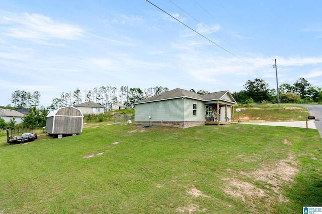 view of yard featuring fence, an outdoor structure, covered porch, and a storage shed