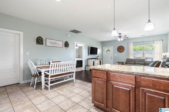 kitchen featuring ceiling fan, open floor plan, light tile patterned floors, visible vents, and pendant lighting