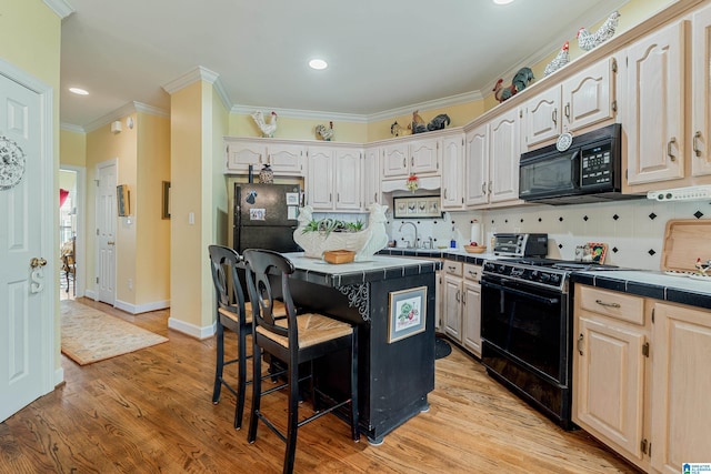 934 Chestnut Oaks Cir, Hoover, AL 35244 - kitchen with black appliances, tile countertops, a breakfast bar area, ornamental molding, and backsplash