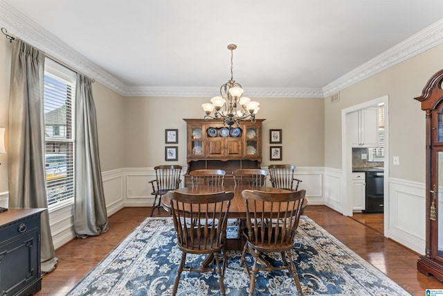 2608 Arbor Way, Hoover, AL 35244 - dining room with a chandelier, wainscoting, dark wood-style flooring, ornamental molding, and a decorative wall
