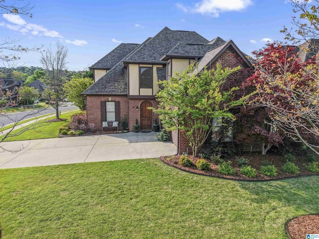 2608 Arbor Way, Hoover, AL 35244 - tudor-style house with stucco siding, a front yard, roof with shingles, and brick siding