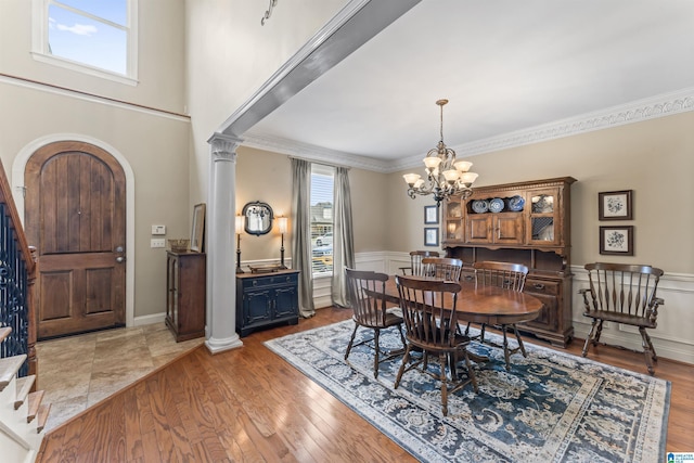 2608 Arbor Way, Hoover, AL 35244 - dining room with arched walkways, a chandelier, stairs, ornamental molding, and wainscoting