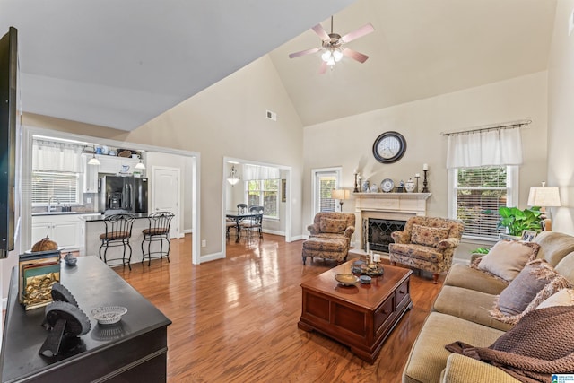 2608 Arbor Way, Hoover, AL 35244 - living room featuring ceiling fan, high vaulted ceiling, light wood-style flooring, a high end fireplace, and baseboards