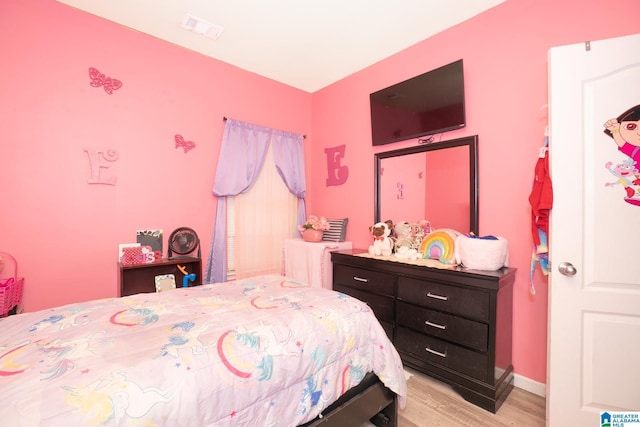 bedroom with baseboards, light wood-style floors, and visible vents