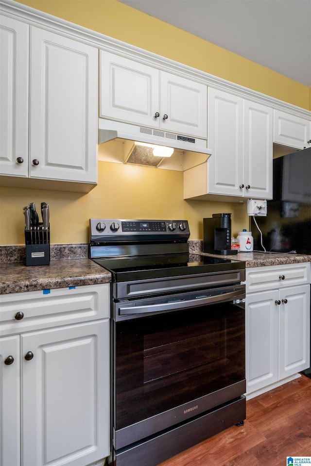 4126 Jubilee Ln, Moody, AL 35004 - kitchen featuring electric range, under cabinet range hood, white cabinets, dark wood-type flooring, and dark countertops