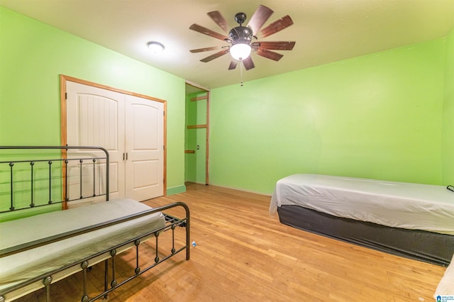 bedroom with a ceiling fan, a closet, and wood finished floors