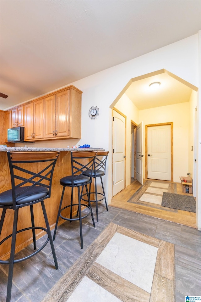 kitchen featuring black microwave and a kitchen bar