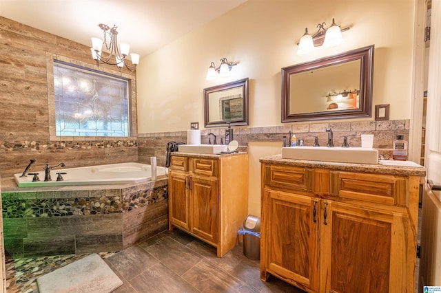 bathroom with a sink, tile walls, a notable chandelier, and a bath