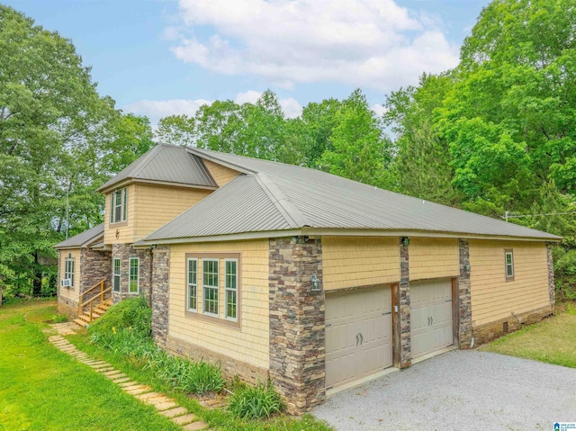 view of home's exterior with metal roof, a garage, and stone siding