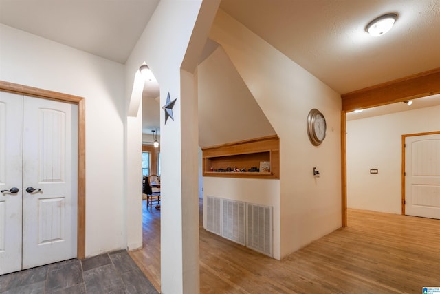 corridor featuring visible vents and wood finished floors