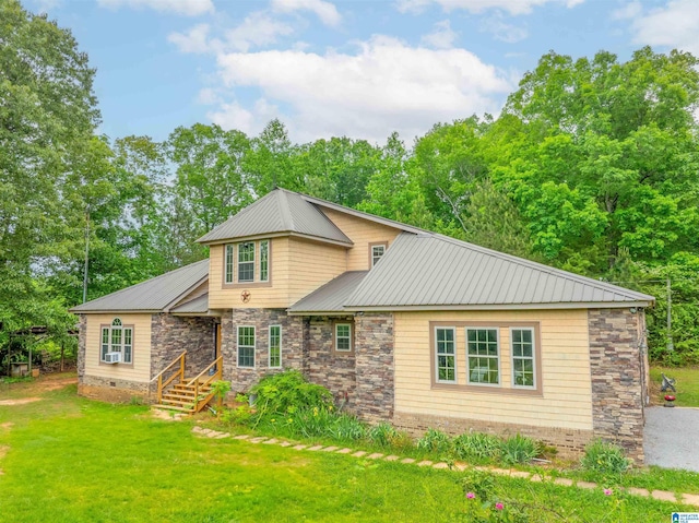 view of front of property featuring stone siding, metal roof, and a front yard
