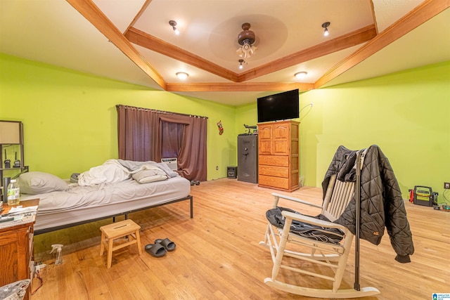 bedroom featuring light wood finished floors and vaulted ceiling with beams