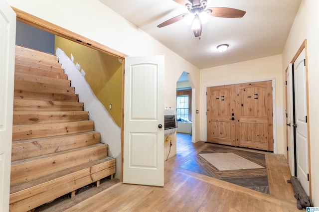 foyer featuring stairs, light wood finished floors, and ceiling fan