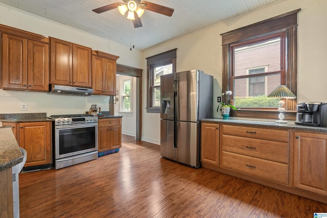 kitchen with stainless steel appliances, under cabinet range hood, a ceiling fan, and brown cabinetry