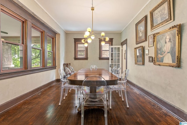 dining room featuring wood-type flooring, a chandelier, baseboards, and ornamental molding