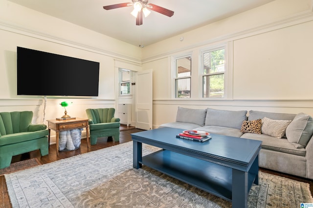 living room featuring a ceiling fan, wood finished floors, and a decorative wall