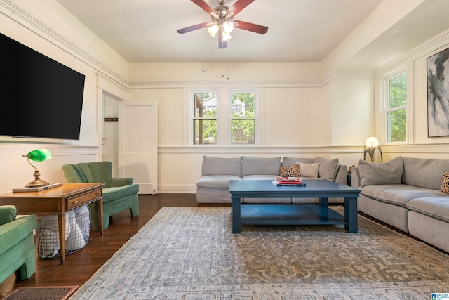 living room with healthy amount of natural light, a ceiling fan, and dark wood finished floors