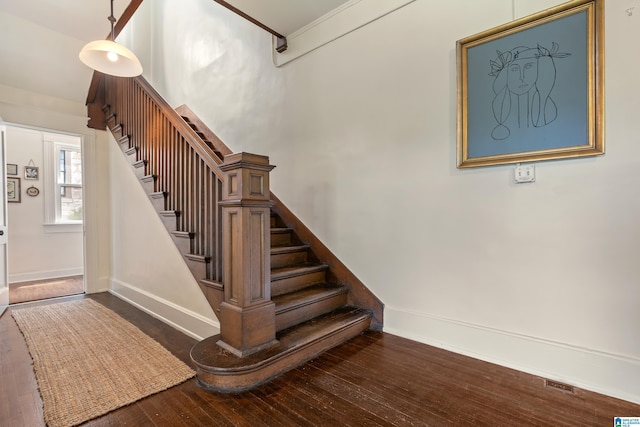 staircase featuring baseboards and wood-type flooring